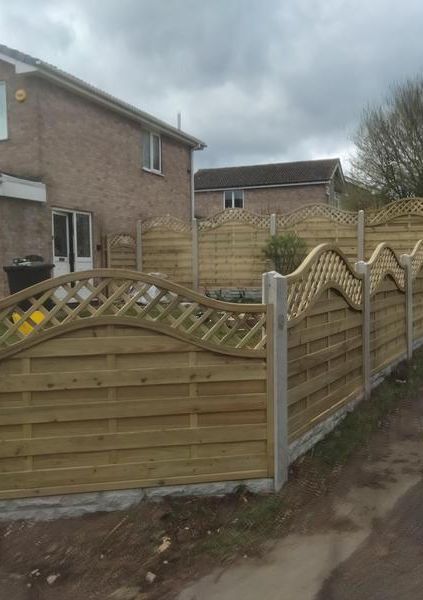 Decorative wave-top fence panels on a sloped boundary